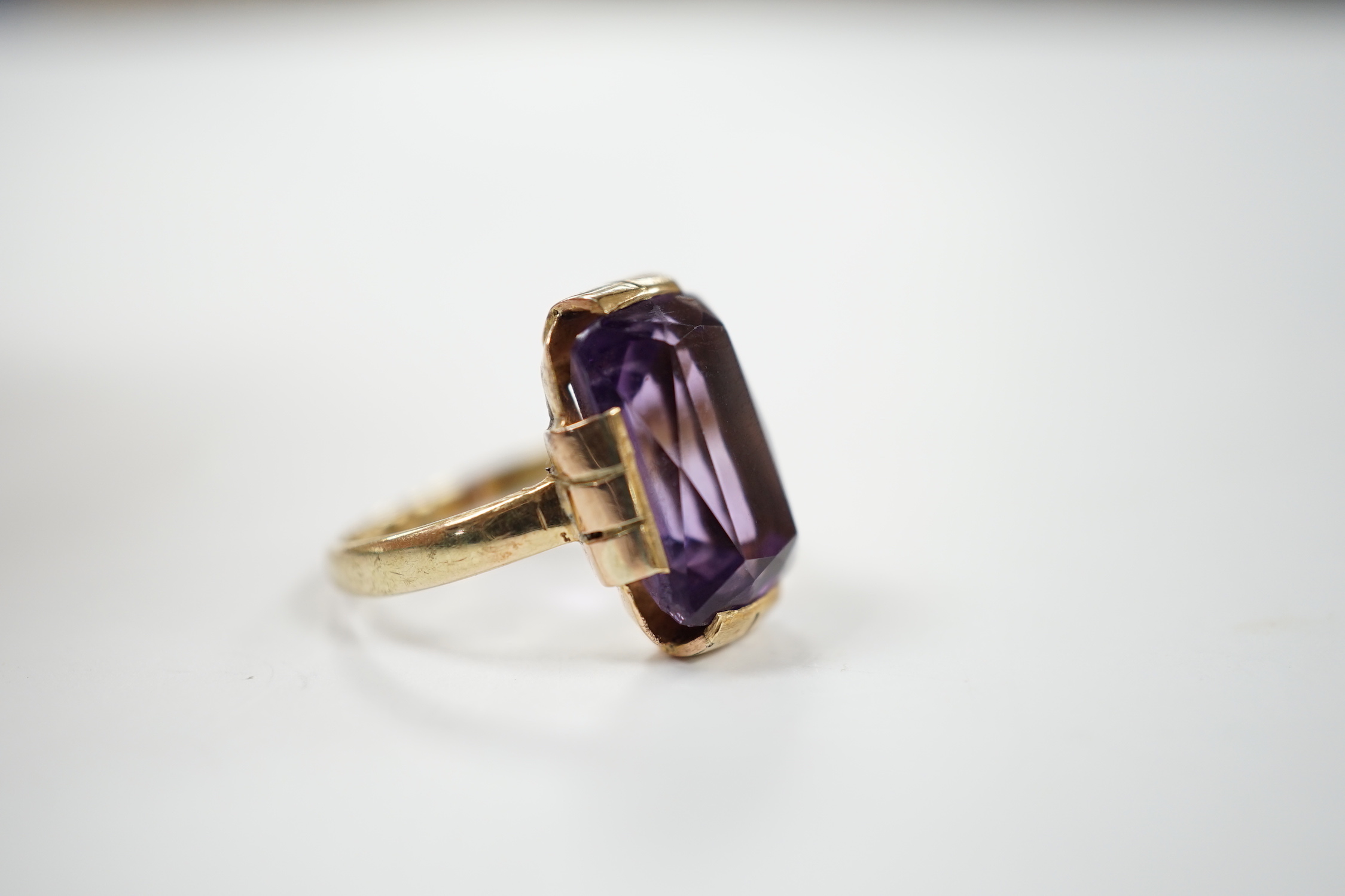 A yellow metal and single stone amethyst set dress ring, size K, gross weight 4.2 grams.